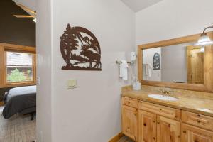 baño con lavabo, espejo y cama en Affordable Mountain Lodge Ski in Ski out en Telluride