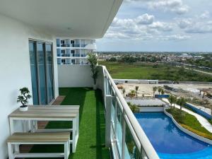 a balcony with a table and a swimming pool at Muji Inspired Beach view in San Fernando