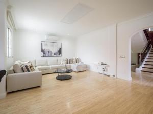 a white living room with a couch and a table at Entire Home Meloneras BBQ Jacuzzi PoolGolf in Meloneras