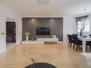 a living room with a tv and a table with chairs at Entire Home Meloneras BBQ Jacuzzi PoolGolf in Meloneras