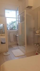 een badkamer met een douche en een glazen deur bij Ô 3 parasols in Sète
