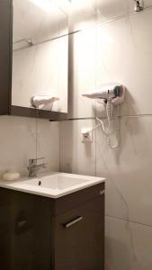 a bathroom with a sink and a mirror and a phone at D&B Apartment 1 in Paralia Katerinis