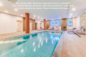 a swimming pool in a hotel room with chairs at Residence Cap Neige in Tignes