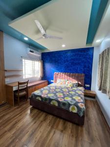 een slaapkamer met een bed, een tafel en een bureau bij Vinayak Homestays in Bhopal