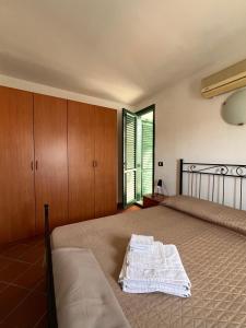 ein Schlafzimmer mit einem Bett mit einem Kleid drauf in der Unterkunft Vista da Re in Aci Castello