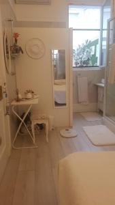 ein kleines Bad mit einem Spiegel und einem Waschbecken in der Unterkunft Ô 3 parasols in Sète