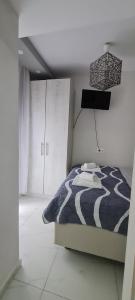 a bedroom with a bed with a black and white comforter at D&B Apartment 1 in Paralia Katerinis