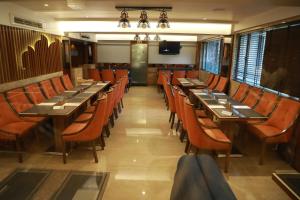 a dining room with long tables and orange chairs at HOTEL ARCHANA RESIDENCY in Mumbai