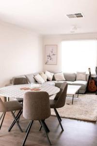 a living room with a table and a couch at Shepparton Family Haven Spacious Retreat in Shepparton