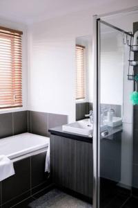 a bathroom with a tub and a sink and a shower at Shepparton Family Haven Spacious Retreat in Shepparton