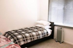 a bedroom with a bed with pillows and a radiator at Shepparton Family Haven Spacious Retreat in Shepparton