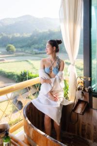 a woman sitting in a bath tub on a balcony at Pupah Kanna Pua-ปู๋ ป๋าล์ คันนา ปัว in Pua