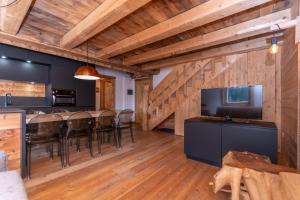 a kitchen and dining room with wooden walls and wooden floors at Arabba - Al Vecio Soler in Livinallongo del Col di Lana