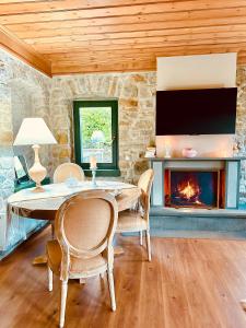 a dining room with a table and a fireplace at Waterfall Kataraktis Vatatsi 