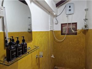 a bathroom with a shower with bottles on the wall at Panorama Beach Hotel in Tangalle