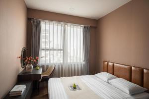 a bedroom with a bed and a desk and a window at SMILE HOME - SOHO COMFORTABLE - BEST LOCATION district 1 in Ho Chi Minh City