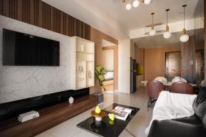 a living room with a television on a wall at SMILE HOME - SOHO APARTMENT COMFORTABLE - BEST LOCATION district 1 in Ho Chi Minh City