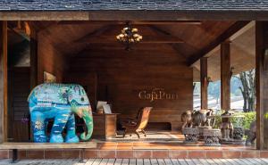 une maison en bois avec un banc et une chaise dans l'établissement GajaPuri Resort Koh Chang, à Ko Chang