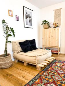 a living room with a couch sitting on a wooden floor at Hacienda Hotel in Friedrichshafen