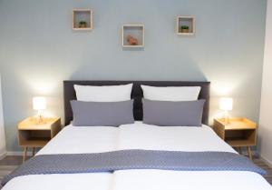 a bedroom with a large bed with two lamps on tables at NOVA Blume I Phantasialand I Cologne I Bonn in Brühl