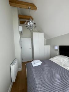 Schlafzimmer mit einem Bett und einem Kronleuchter in der Unterkunft Nadmorskie Ostrowo in Ostrowo