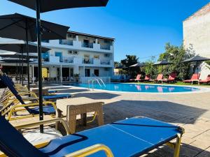 un hotel con una piscina con sillas y sombrillas en Melitsa corfu hotel, en Sidari