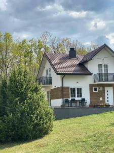 une maison blanche avec un toit et une cour dans l'établissement Villa Pluto, à Gnjilane