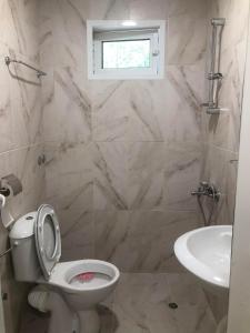 La salle de bains est pourvue de toilettes, d'un lavabo et d'une fenêtre. dans l'établissement Villa Stela Mare, à Sunny Beach