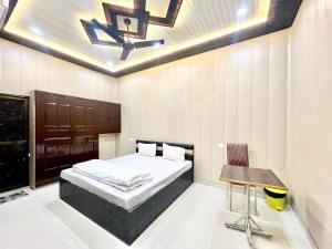 1 dormitorio con cama, mesa y techo en Hotel DEV VILLA GUEST HOUSE ! VARANASI fully-Air-Conditioned hotel at prime location, near Kashi Vishwanath Temple, and Ganga ghat en Varanasi