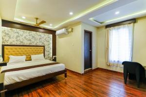 a bedroom with a bed and a desk and a window at La Courtyard in Puducherry