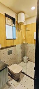a bathroom with a toilet and a window in it at Maple Tree, Lucknow - Couple Friendly in Lucknow