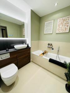 a bathroom with a toilet and a sink and a tub at Luxurious & Spacious 2 Bed Apartment- Private Parking in Kent