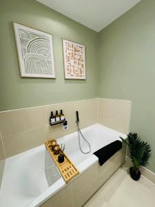 a bath tub in a bathroom with a potted plant at Luxurious & Spacious 2 Bed Apartment- Private Parking in Kent