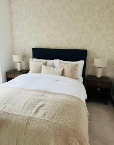 a bedroom with a large white bed with two night stands at Luxurious & Spacious 2 Bed Apartment- Private Parking in Kent