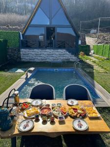 uma mesa com comida ao lado de uma piscina em Perla em Hendek