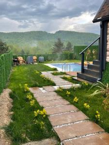 a garden with a stone path next to a swimming pool at Perla in Hendek