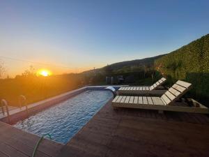 ein Pool mit Bank und Sonnenuntergang in der Unterkunft Perla in Hendek