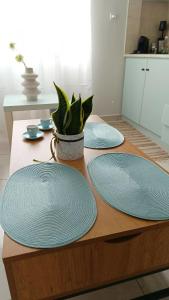 stół z dwoma niebieskimi płytkami i rośliną na nim w obiekcie Demy's apartments w mieście Kardítsa