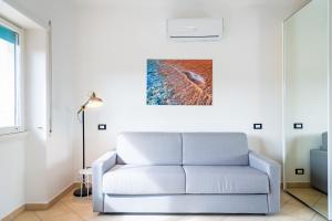 un soggiorno con divano e un dipinto sul muro di Appartamento Il Mare e Dintorni a Portoferraio