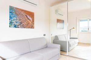 un soggiorno con divano bianco e sedia di Appartamento Il Mare e Dintorni a Portoferraio