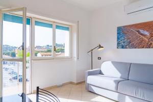 un soggiorno con divano e finestre di Appartamento Il Mare e Dintorni a Portoferraio Altre 6 foto