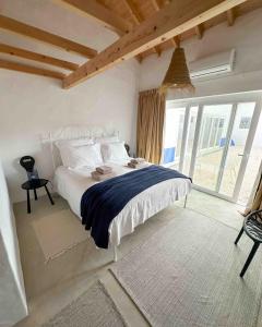 1 dormitorio con cama blanca y ventana grande en Valle D`Água - Casas de campo en Vale de Água