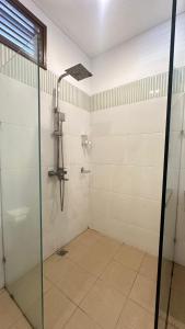 a bathroom with a shower with a glass door at Bukawa Lodge Jimbaran in Jimbaran