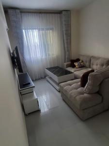 uma sala de estar com um sofá e uma mesa em Rozina Apartments em Nairobi