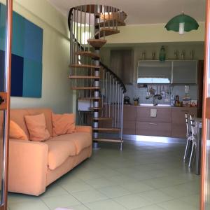 un soggiorno con divano e una scala a chiocciola di Adriana casa vacanze mare Etna Sicilia ad Acireale