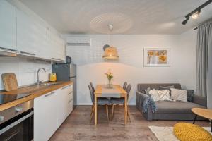 a kitchen and living room with a table and a couch at Relax apartment Split area with jacuzzi and mountain view in Žrnovnica