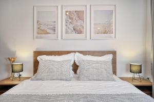 a bedroom with a bed with four pictures on the wall at Relax apartment Split area with jacuzzi and mountain view in Žrnovnica
