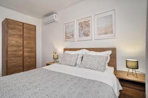 a bedroom with a bed with white sheets and pillows at Relax apartment Split area with jacuzzi and mountain view in Žrnovnica +55 photos