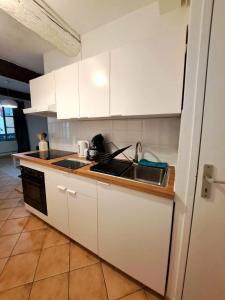 a kitchen with white cabinets and a sink at T2 Proche du port, zone piétonne in Toulon