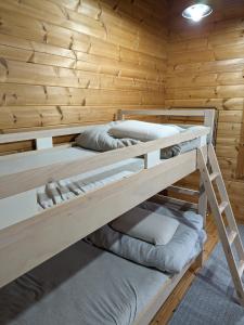 two bunk beds in a wooden cabin at Log Cottage be with nature in Furano